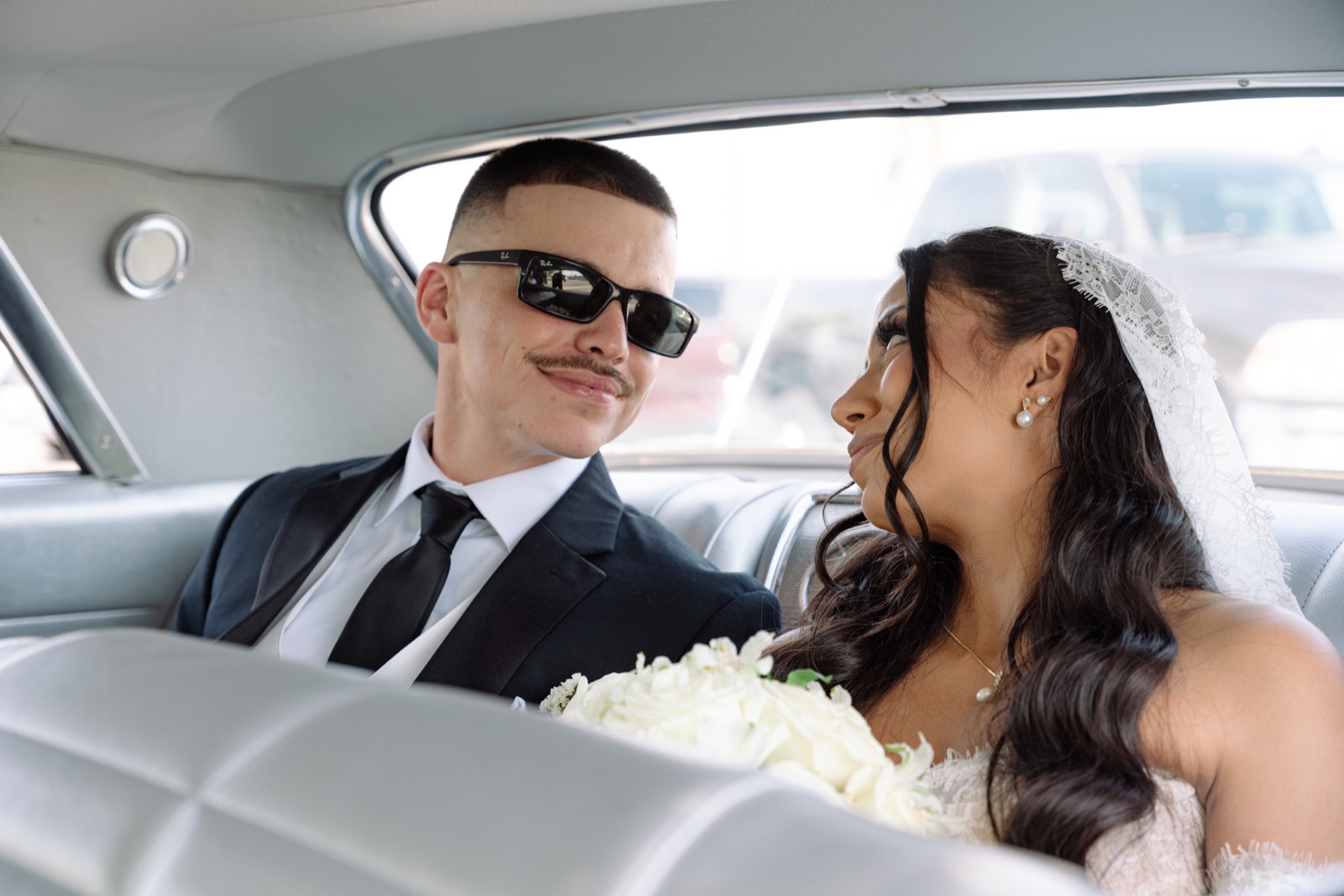 Bride and groom sharing a quiet moment inside a classic car