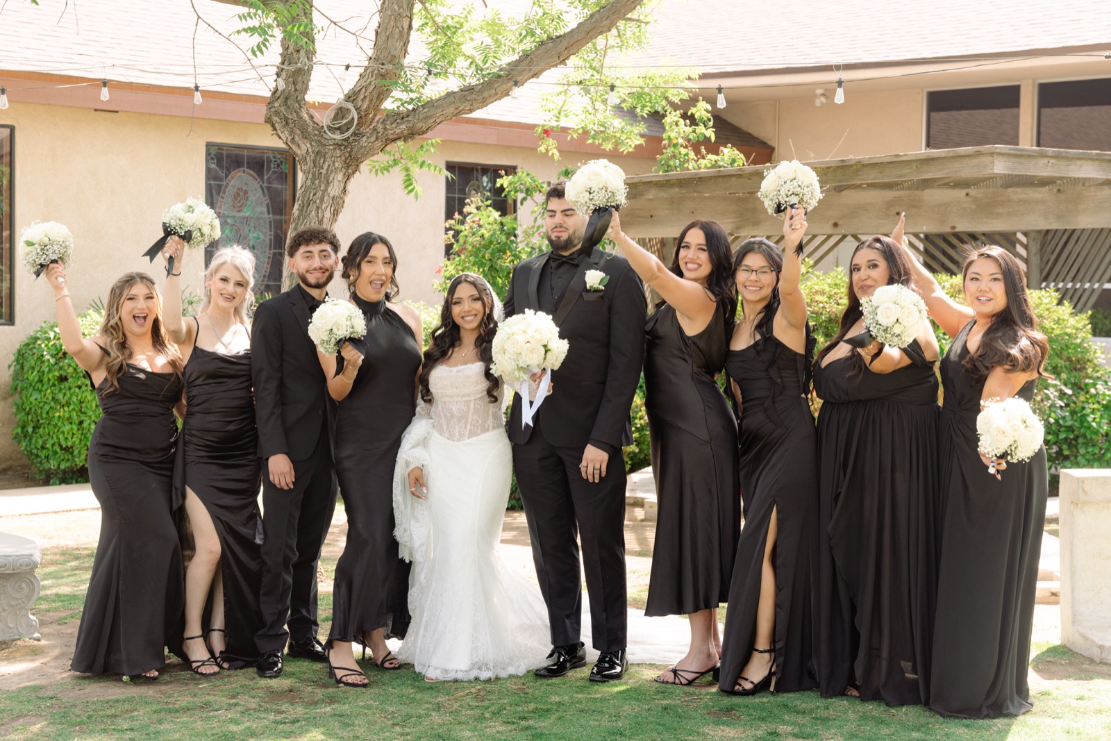 Bride and groom with their wedding party holding white bouquets